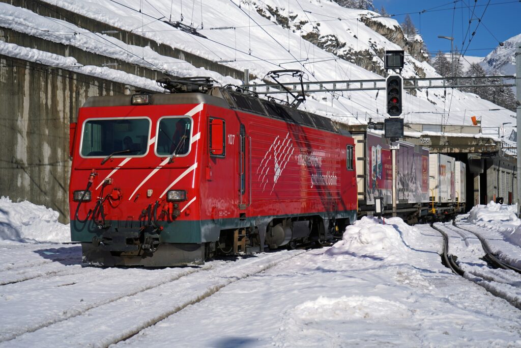 Der Güterzug fährt gerade in den Bahnhof Zermatt ein.